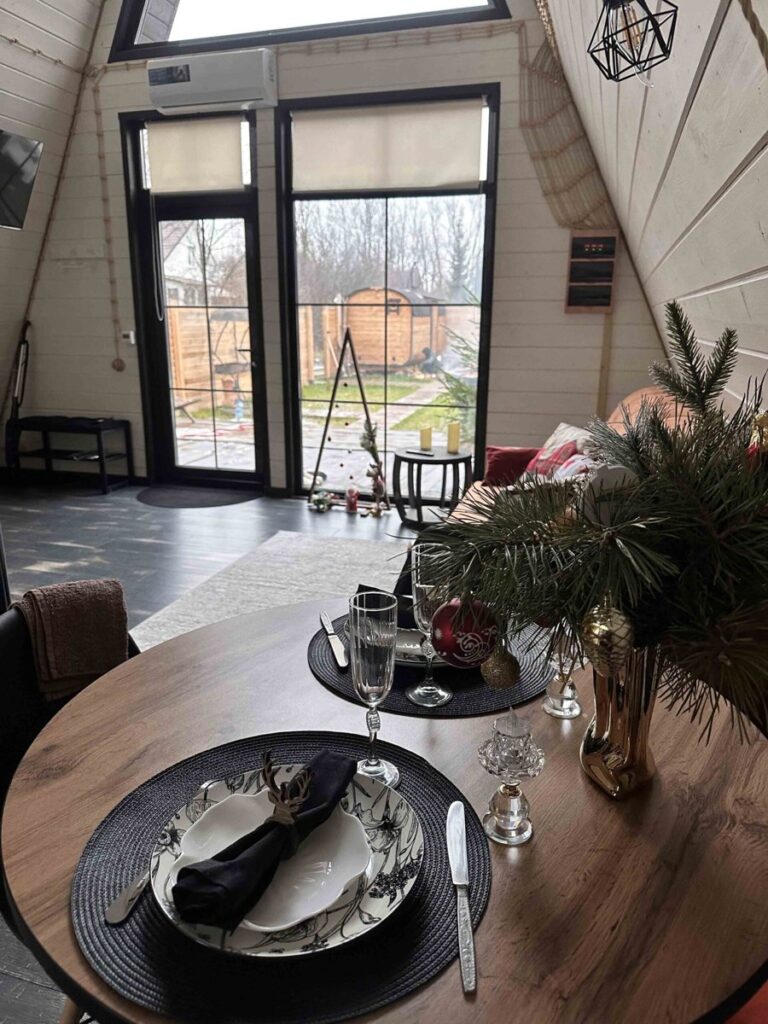 Дом A-frame с баней-бочкой и чаном, до 4 гостей: обеденный стол у окон