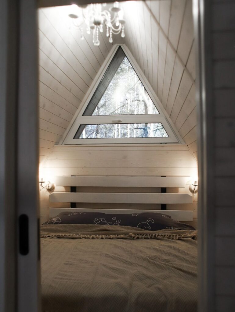 Средний A-frame со своей купелью на террасе до 6 гостей, A-frame домики Forest Tale в Дегтярске: спальня с треугольным окном