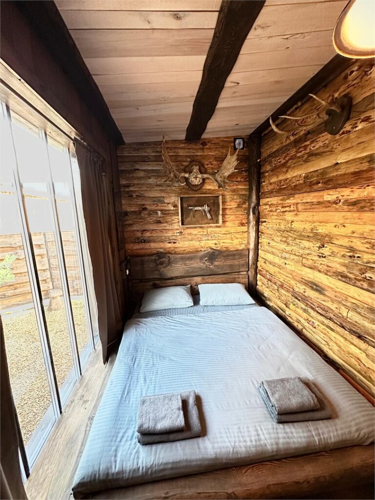Дом охотника «Гастон» с каминным залом и SPA-чаном до 4 гостей: спальня у окна