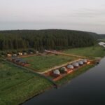 Глэмпинг Scandi Village в Колюткино, общий вид: домики вдоль реки сверху