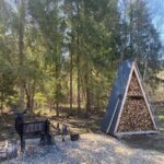 Глэмпинг Vlesu glamping у деревни Шульгино, общий вид: дровник в лесу