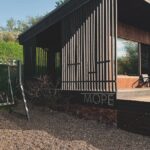 Глэмпинг Panorama Village на берегу Волги, общий вид: домик и качели на склоне