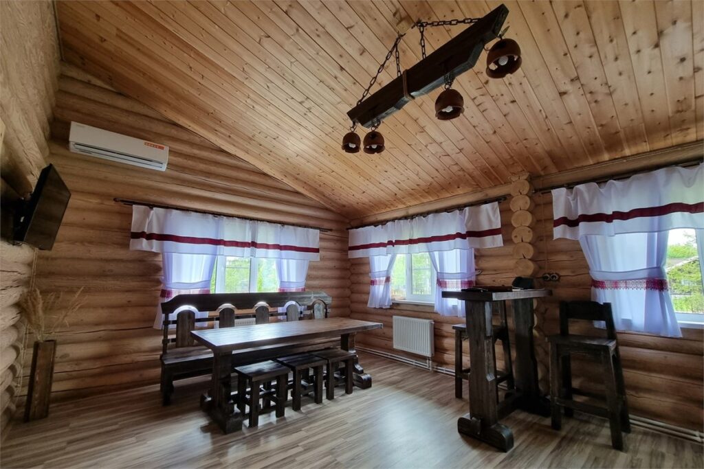 Бревенчатое имение 100 м² на 2 спальни с парной до 4 гостей: гостиная с деревянным столом