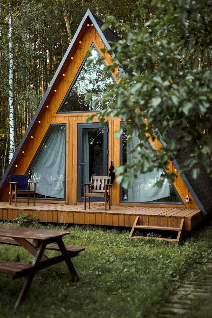 Маленький A-frame дом 36 м² с подвесным креслом, шесть одинаковых: дом и стол для пикника