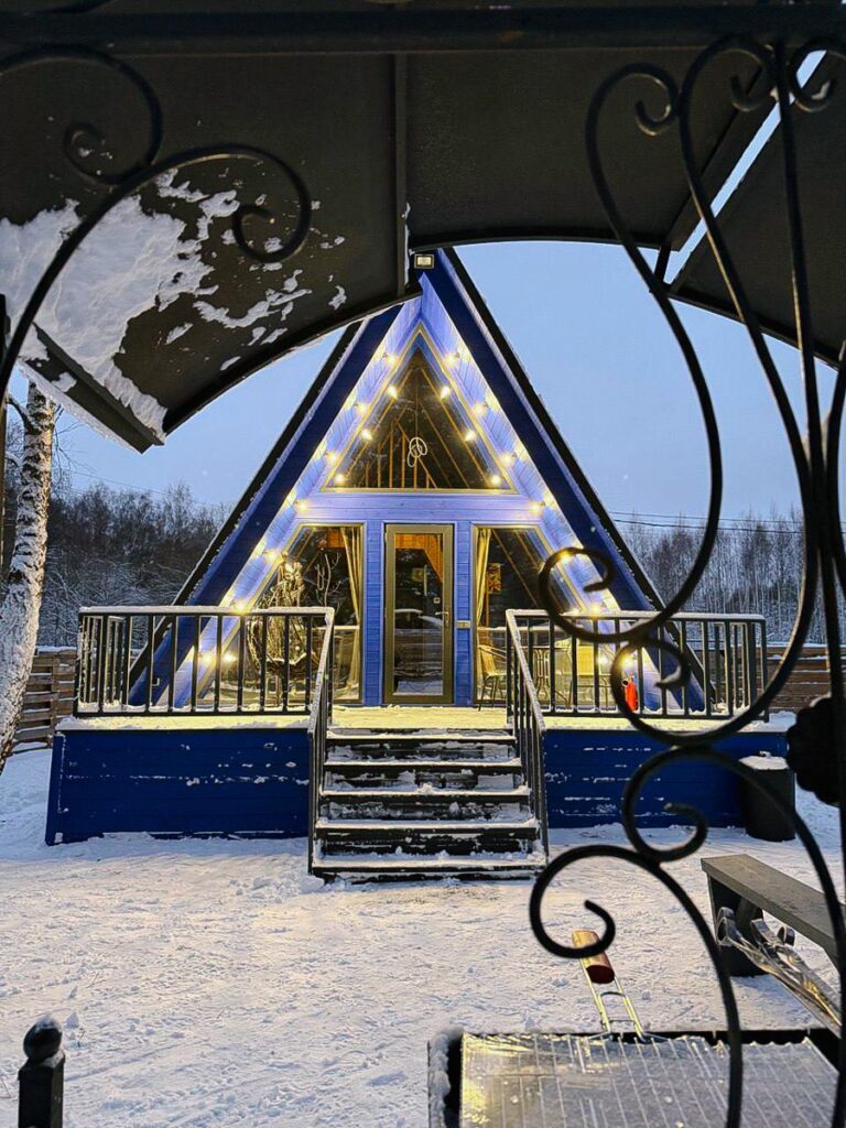 А-фрейм 54 м² с тёмно-синим интерьером и чаном до 4 гостей, «Звёзды Леса»: дом зимним вечером