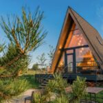 Глэмпинг Трофимов Берег в Васильевском, общий вид: A-frame дом среди берёз