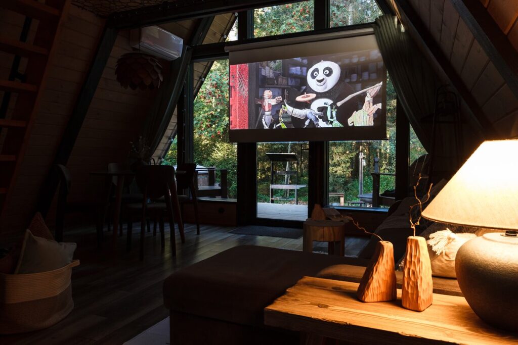 Треугольный A-frame 45 м² с купелью и гриль-очагом, четыре одинаковых: проектор в гостиной
