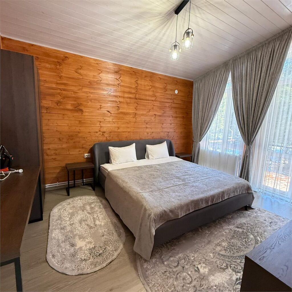 Шале Peak Chalet с панорамными окнами на горы до 8 гостей: спальня с деревянной стеной