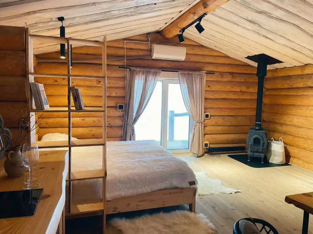 Бревенчатый дом 56 м² с камином и кухней-гостиной до 3 гостей: спальная зона и камин