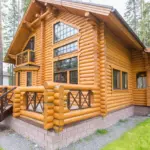 Коттеджи Рощино Вилладж в Рощино, общий вид: бревенчатый коттедж в соснах