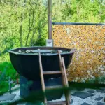 Гостевые дома Ambar House в Амельфино, общий вид: банный чан у поленницы