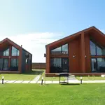 Барнхаусы Suzdal Villa в Троица-Береге, общий вид: барнхаусы на лужайке
