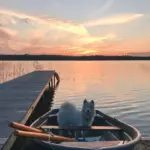 Глэмпинг Shanti Home Ozero у Громово, общий вид: пирс и лодка на закате