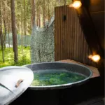 А-фрейм Shalash & Forest в лесу у Серебряного лога, общий вид: купель на террасе