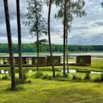 Парк-отель Рассвет на Горьковском море, общий вид: дома у воды среди сосен