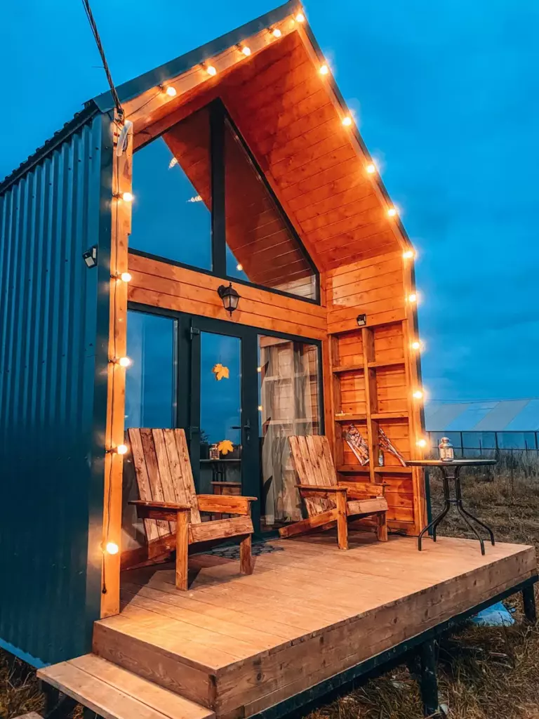 Барнхаус Hygge House с панорамным окном и баней-бочкой до 4 гостей: терраса с креслами и гирляндой