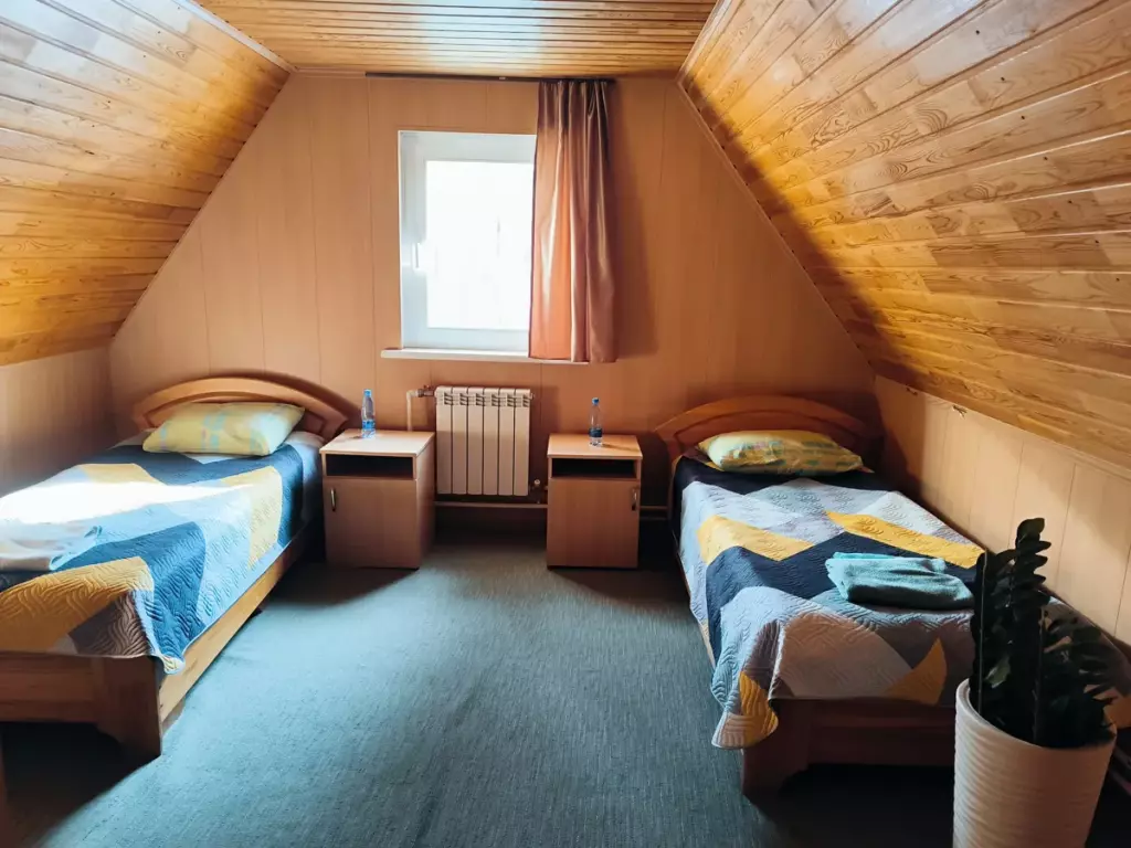 Двухэтажный коттедж 120 м² с огороженным участком до 11 гостей: спальня в мансарде