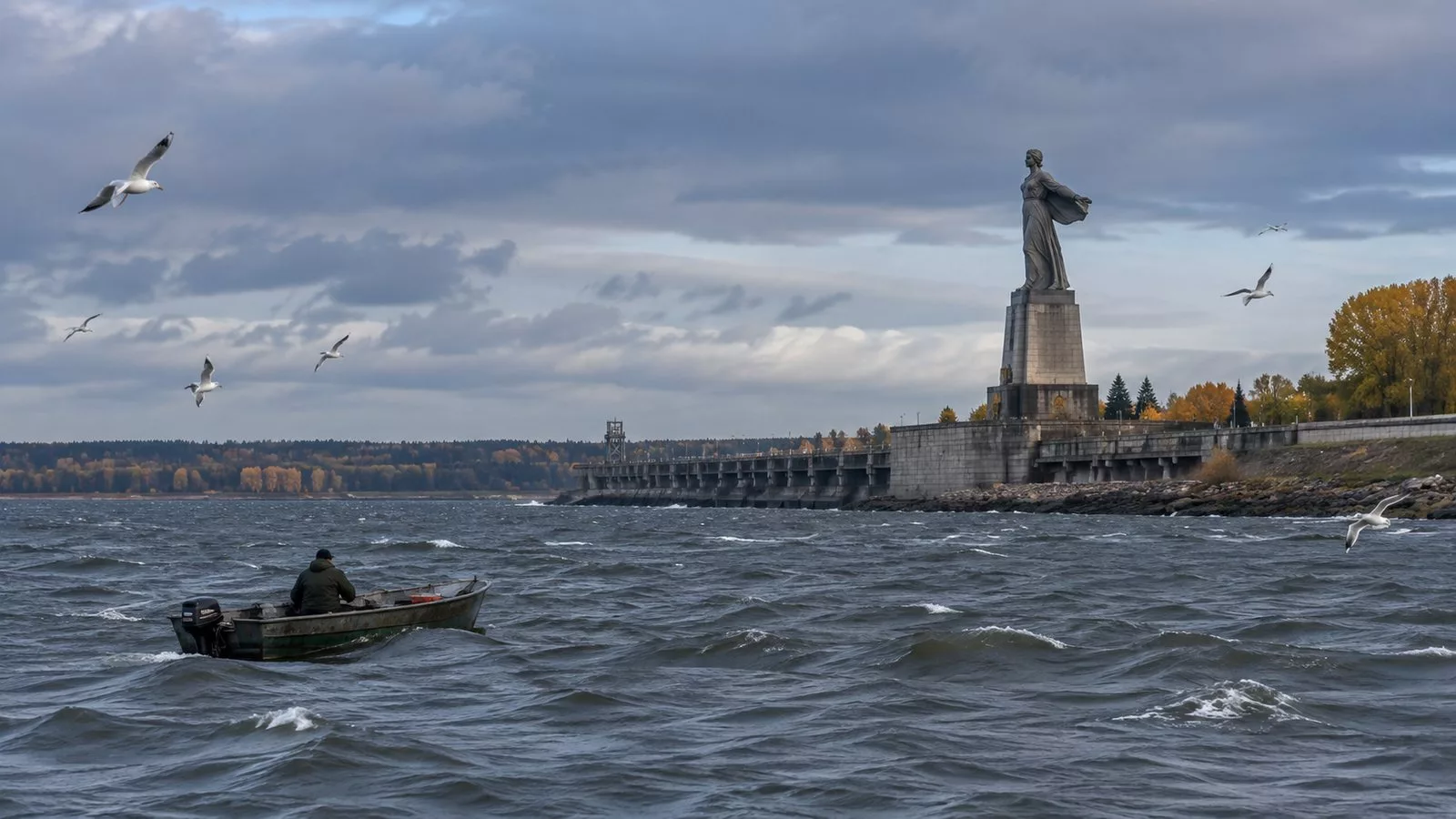 Высокая фигура женщины на постаменте у плотины Рыбинского водохранилища, ветреный осенний день, чайки и лодка рыбака на волнах